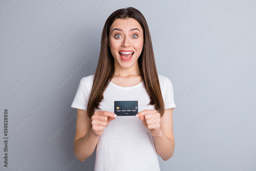 Portrait of astonished positive girl hold credit card impressed easy baking service payment wear style stylish outfit isolated over gray color background Portrait of astonished positive girl hold credit card impressed easy baking service payment wear style stylish outfit isolated over gray color background