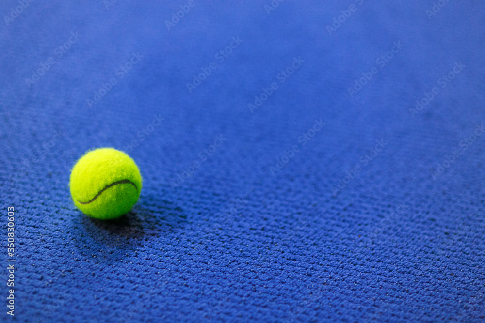 Tennis ball on blue indoor carpet