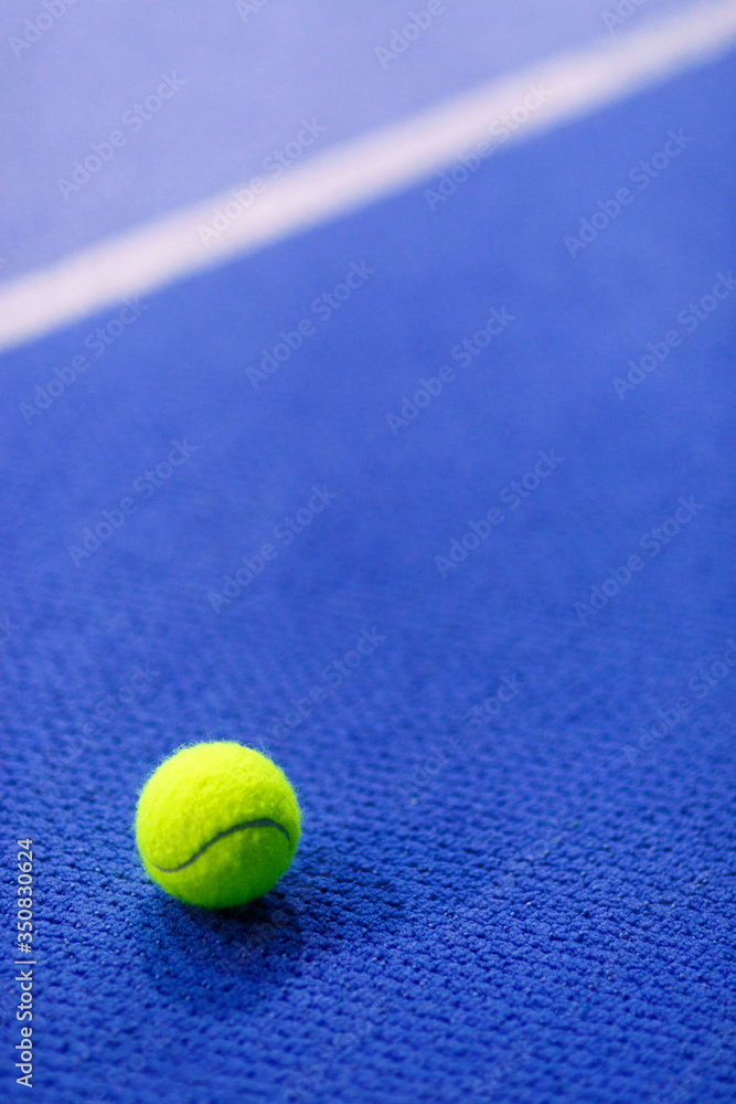 Tennis ball on blue indoor carpet