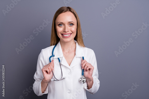 Close-up portrait of her she nice attractive cheerful cheery friendly blonde girl skilled experienced doc head physician pediatrician isolated over grey violet pastel color background