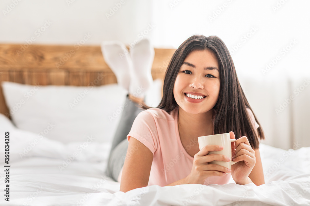 Asian Girl Having Coffee Lying In Bed In Cozy Bedroom Asian Girl Having Coffee Lying In Bed In Cozy Bedroom