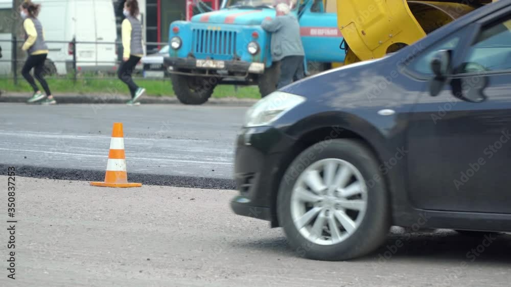 Yellow road roller rides on a road while laying asphalt. Building new road. Road repair concept Yellow road roller rides on a road while laying asphalt. Building new road. Road repair concept