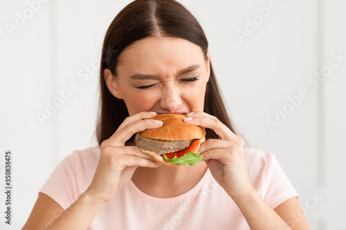 Girl Eating Burger Enjoying Fast Food At Home