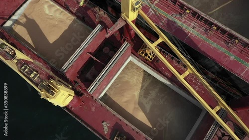 Zoom out from bulk carrier freight storage filled with soybean or wheat transported during export or import logistics. View of two boats during underway ship to ship transfer operation in open sea