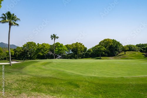 View of golf course with beautiful putting green. Golf course with a rich green turf beautiful scenery.