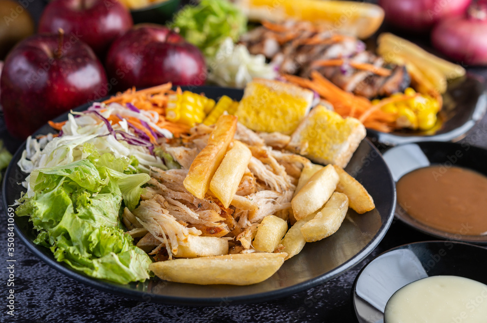 Sliced chicken steak with bread, carrots, cauliflower, turnips, and corn on a black plate. Sliced chicken steak with bread, carrots, cauliflower, turnips, and corn on a black plate.