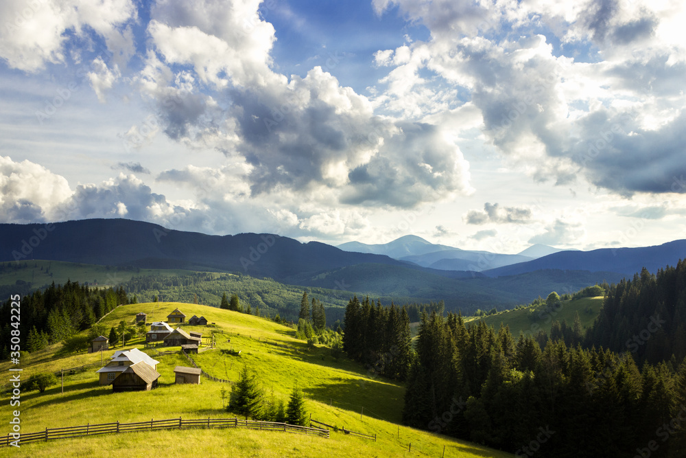 Summer landscape in the mountains. Beautiful sky and mountains. Wonders of wild nature. Houses in the mountains.