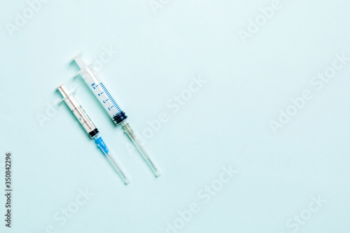 Top view of different syringes for injection on colorful background. Medical equipment concept with copy space