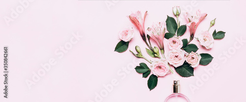 Obraz na plátně Women's perfume bottle and roses flowers on pink background