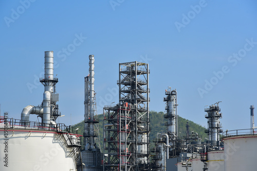 Oil refinery plant from industry, Refinery Oil storage tank and pipe line steel with blue sky background.