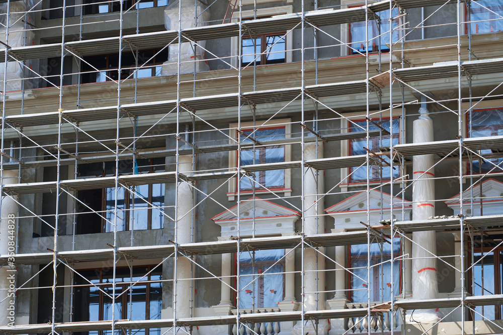 scaffolding at the facade of a building under construction, multi-storey building, without people scaffolding at the facade of a building under construction, multi-storey building, without people