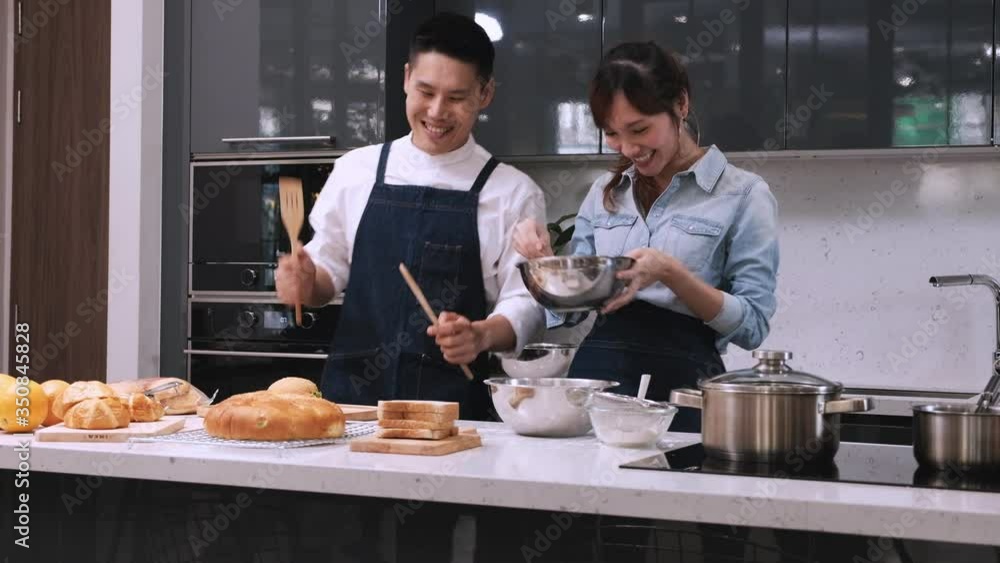 Man and woman dancing happily while preparing bakery in the kitchen. Man and woman dancing happily while preparing bakery in the kitchen.