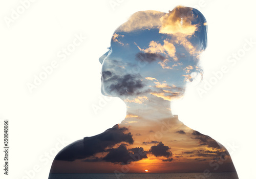 Double exposure portrait of a woman in contemplation at sunset time