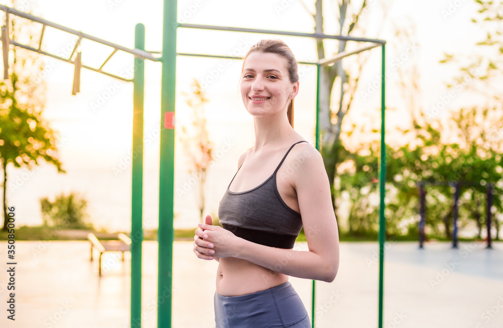 portrait of a young smiling fit woman after outdoor workout