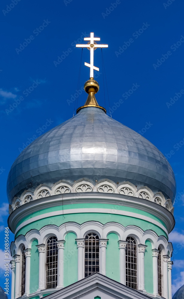 Dome of the Orthodox Church against the blue sky with clouds in summer closeup