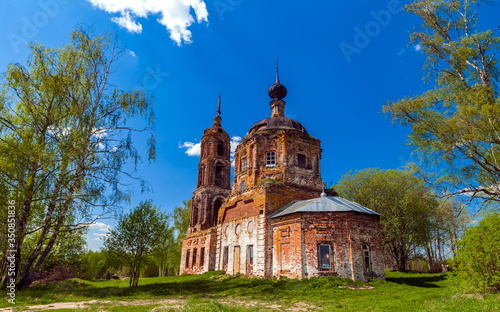 Abandoned Orthodox Church in summer against the blue sky and white clouds