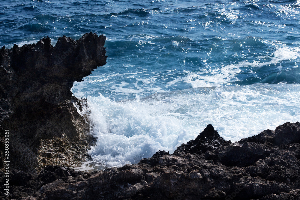 The rocky, steep shore. Beautiful view of the stormy restless sea. Tidal hole