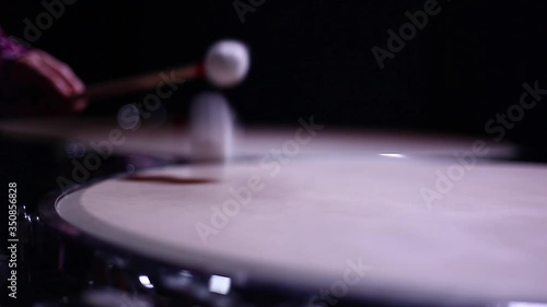 A man playing timpani in a dark room, tilt and small depth of field. photo
