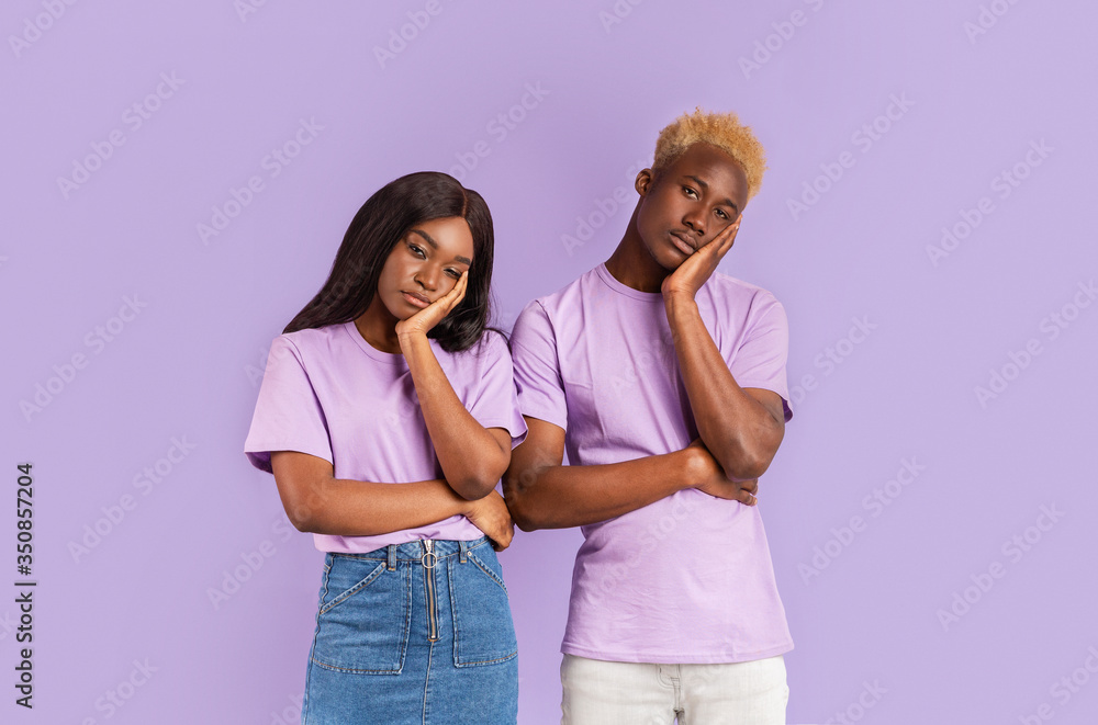 Bored African American couple with dull facial expressions on color background Bored African American couple with dull facial expressions on color background