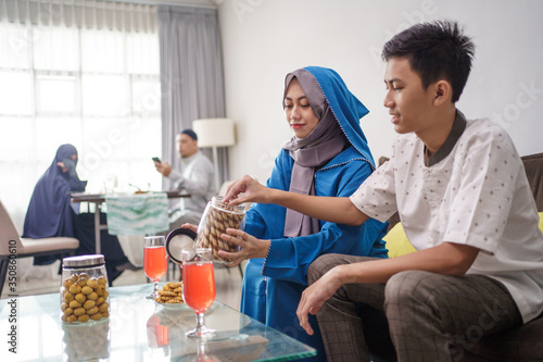 boy and girl enjoying snacks on eid mubarak celebration with family at home. hari raya idul fitri tradition © Odua Images