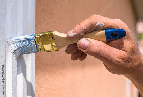 man's hand painting a window sill close up. homework.