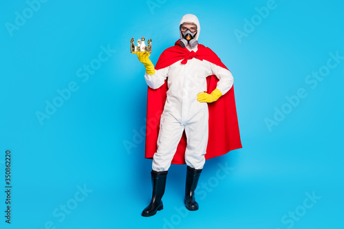 Best strength ncov disinfection service concept. Man doctor hold golden crown wear white suit yellow goggles latex gloves gas respirator red costume mantle isolated blue color background