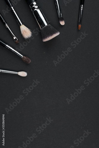 brushes for make-up on different size a black background. top view. copyspace