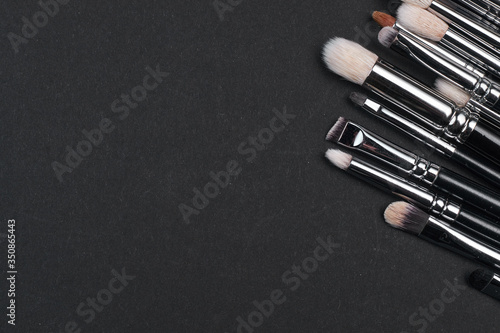 brushes for make-up on different size a black background. top view. copyspace.