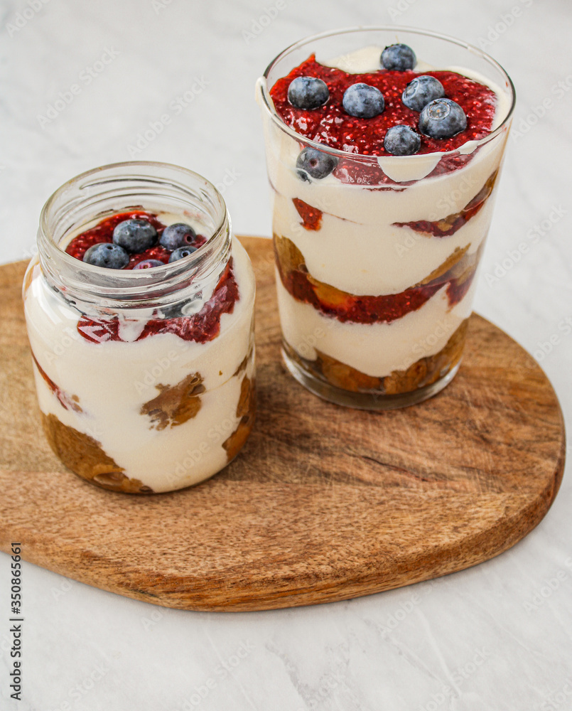 Healthy cheesecake in a mason jar and on top of a wooden board. Food styling & food photography for the culinary blog.