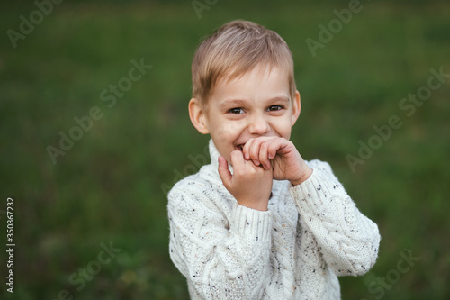 Portrait of a little boy 5 years old. Photo taken outdoors in the forest. Happy baby smiling