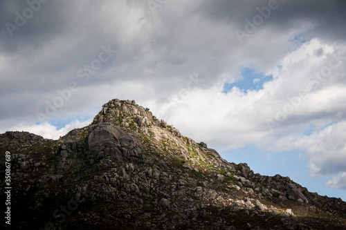 A rocky mount peak under cloudy skies