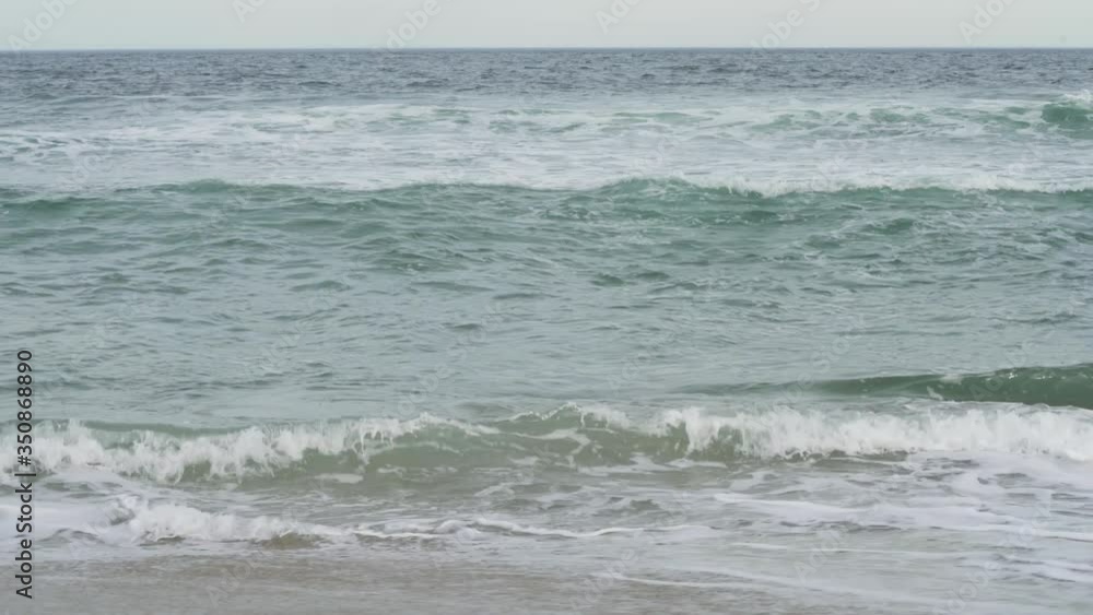 4K. Sandy coastline. A large, foaming wave, beating against the shore, turning into spray. Amazing force of nature . 4K. Sandy coastline. A large, foaming wave, beating against the shore, turning into spray. Amazing force of nature .