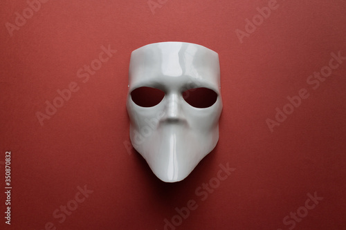 Theatre concept with the white masks on trendy terracotta background. Anonimous, Incognito, Conspiracy concept. Place for text. Flat lay style. Top view