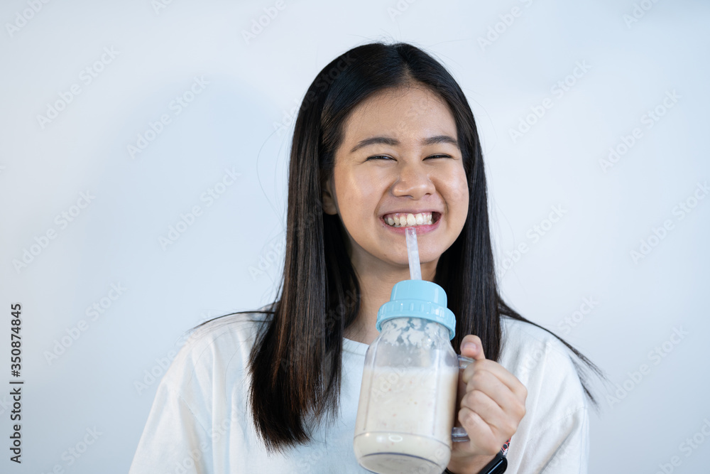 Asian young girl is drinking a yogurt smoothie. Asian young girl is drinking a yogurt smoothie.