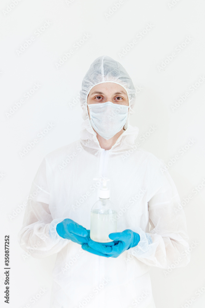 A man in a protective suit holds an antibacterial antiseptic gel for hand disinfection. Health care prevention during an outbreak of the flu virus and a coronavirus epidemic A man in a protective suit holds an antibacterial antiseptic gel for hand disinfection. Health care prevention during an outbreak of the flu virus and a coronavirus epidemic