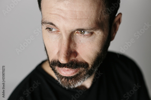 Close-up portrait of a bearded middle-aged man against neutral background