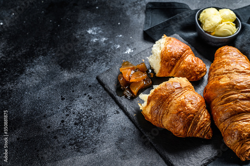 Homemade croissants with pear marmalade. Black background. Top view. Copy space.