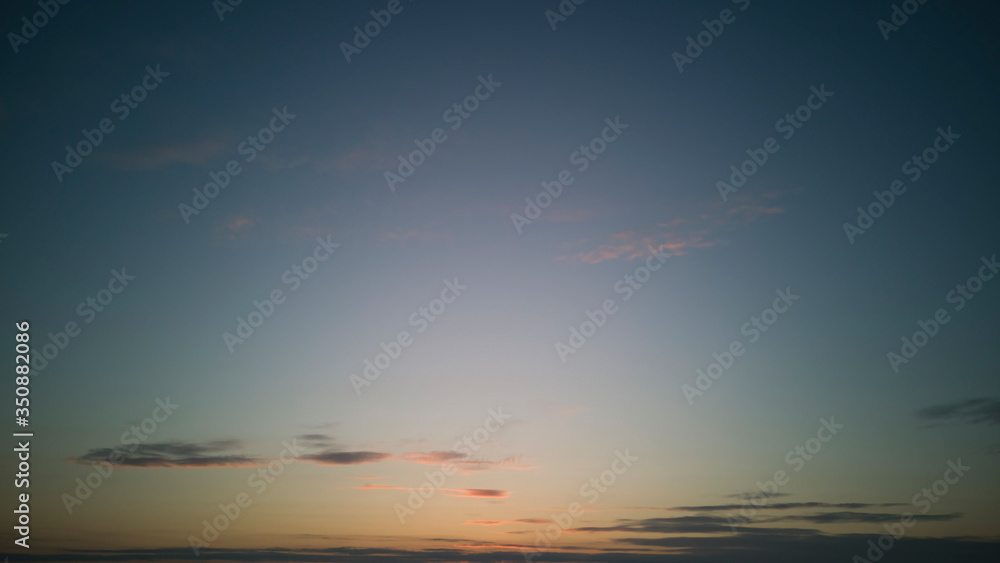 Clear,almost cloudless sky at sunset or sunrise with minimum of light strokes of clouds, with light gradient from lower border in center.Horizontal banner,texture.Abstract backdrop for site,blog,model
