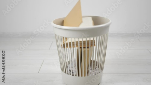 Throwing away multiple books into trash bin. Outdated literature.