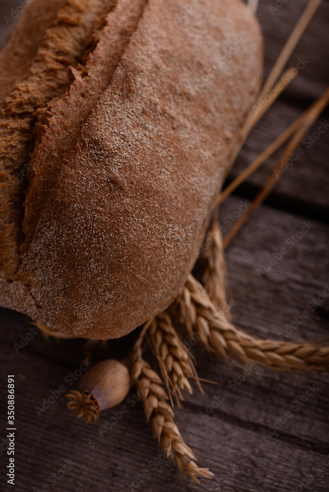 Fresh baked crispy bread on an old rustic wooden table. French bread. Bakery food background. Fresh baked crispy bread on an old rustic wooden table. French bread. Bakery food background.