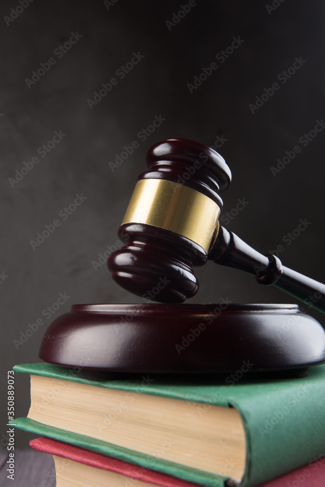 Wooden gavel and books on wooden table - law and auction concept Wooden gavel and books on wooden table - law and auction concept