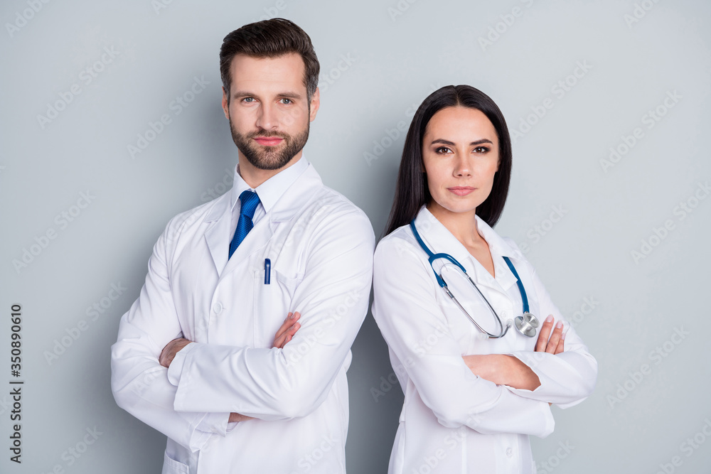 Photo of handsome doc guy medic lady emergency patient consultation virology clinic stand back-to-back arms crossed experienced doctors wear lab coats isolated grey color background Photo of handsome doc guy medic lady emergency patient consultation virology clinic stand back-to-back arms crossed experienced doctors wear lab coats isolated grey color background