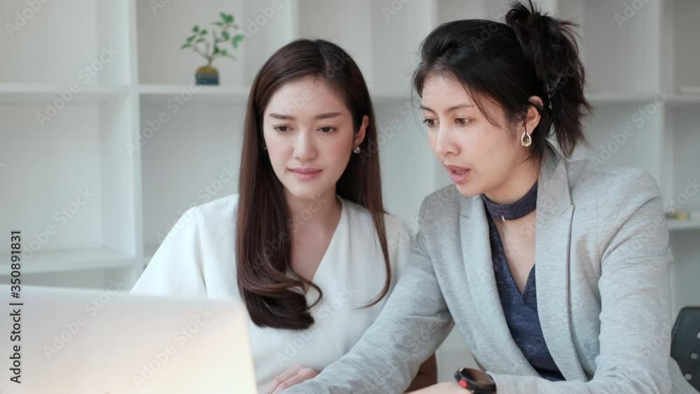 two asian businesswoman is sitting to talk or meeting, happy work, and a smile in the modern office space. Team work and help plan marketing for successful work. Concept business start up back to work two asian businesswoman is sitting to talk or meeting, happy work, and a smile in the modern office space. Team work and help plan marketing for successful work. Concept business start up back to work