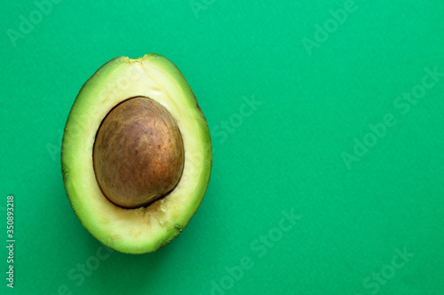 Cut avocado. Avocado on a pastel green background. Free space for text. Top view. Flat lay. Minimalism and food.