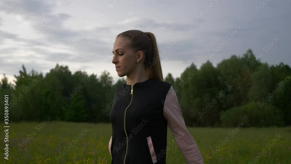 Woman Doing Exercise Warming up Workout Fitness in Grass Field. Countryside Rural Scenery. Rainy Clouds Weather Spring season. 2x Slow motion - 1/2 speed of 60 FPS. Woman Doing Exercise Warming up Workout Fitness in Grass Field. Countryside Rural Scenery. Rainy Clouds Weather Spring season. 2x Slow motion - 1/2 speed of 60 FPS.