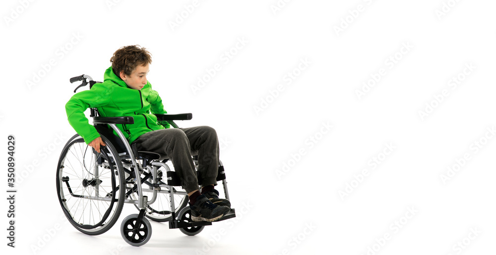 Little boy in wheelchair on white background , boy is sitting in a wheelchair on a white background. Hospital patient with disability Little boy in wheelchair on white background , boy is sitting in a wheelchair on a white background. Hospital patient with disability