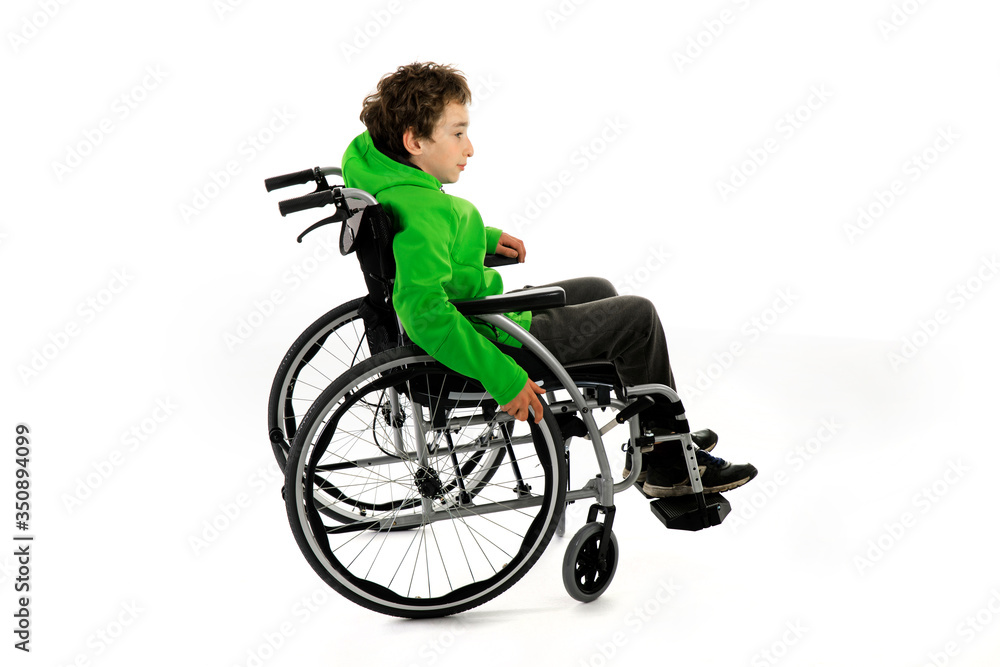 Little boy in wheelchair on white background , boy is sitting in a wheelchair on a white background. Hospital patient with disability Little boy in wheelchair on white background , boy is sitting in a wheelchair on a white background. Hospital patient with disability