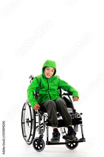 Little boy in wheelchair on white background , boy is sitting in a wheelchair on a white background. Hospital patient with disability