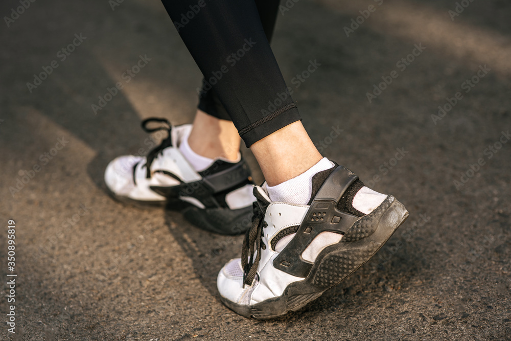 Runner woman feet running on road closeup on shoe. Sports healthy lifestyle concept.