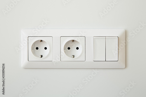 power sockets near switch on white wall
